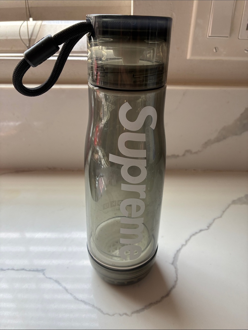 Supreme Smoke Transparent Bottle with White Vertical Logo